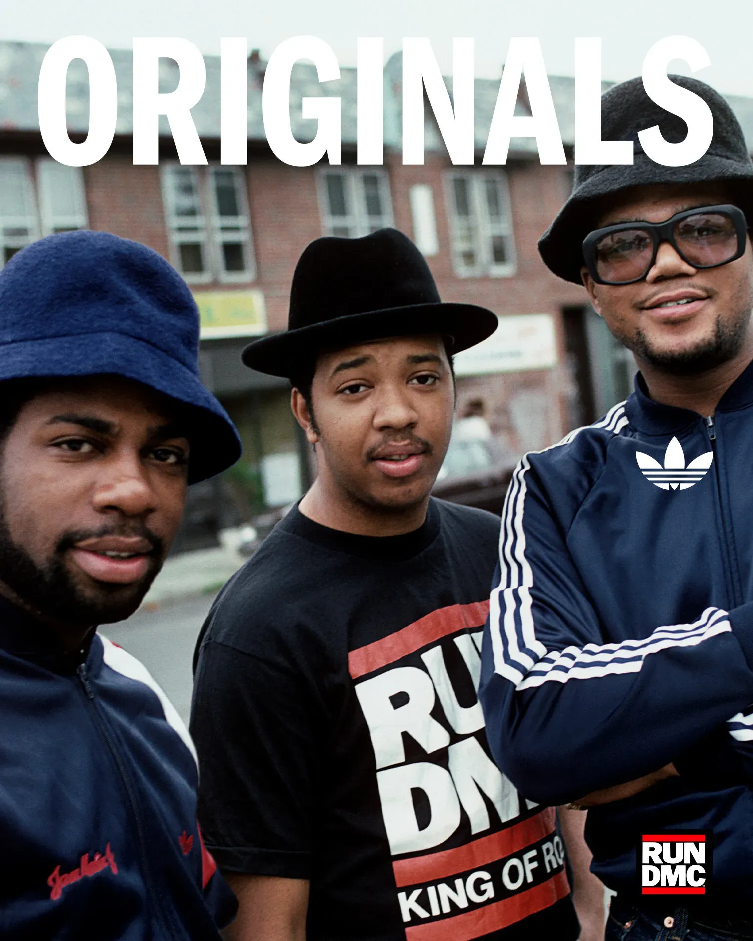 Three Run-DMC members in adidas tracksuits and hats posing under large white ORIGINALS lettering