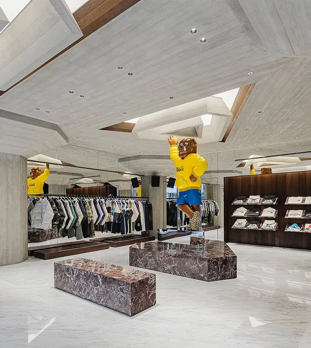Palace store with a giant bulldog figure in a yellow Palace hoodie, clothing rails, mirrored walls and red marble benches
