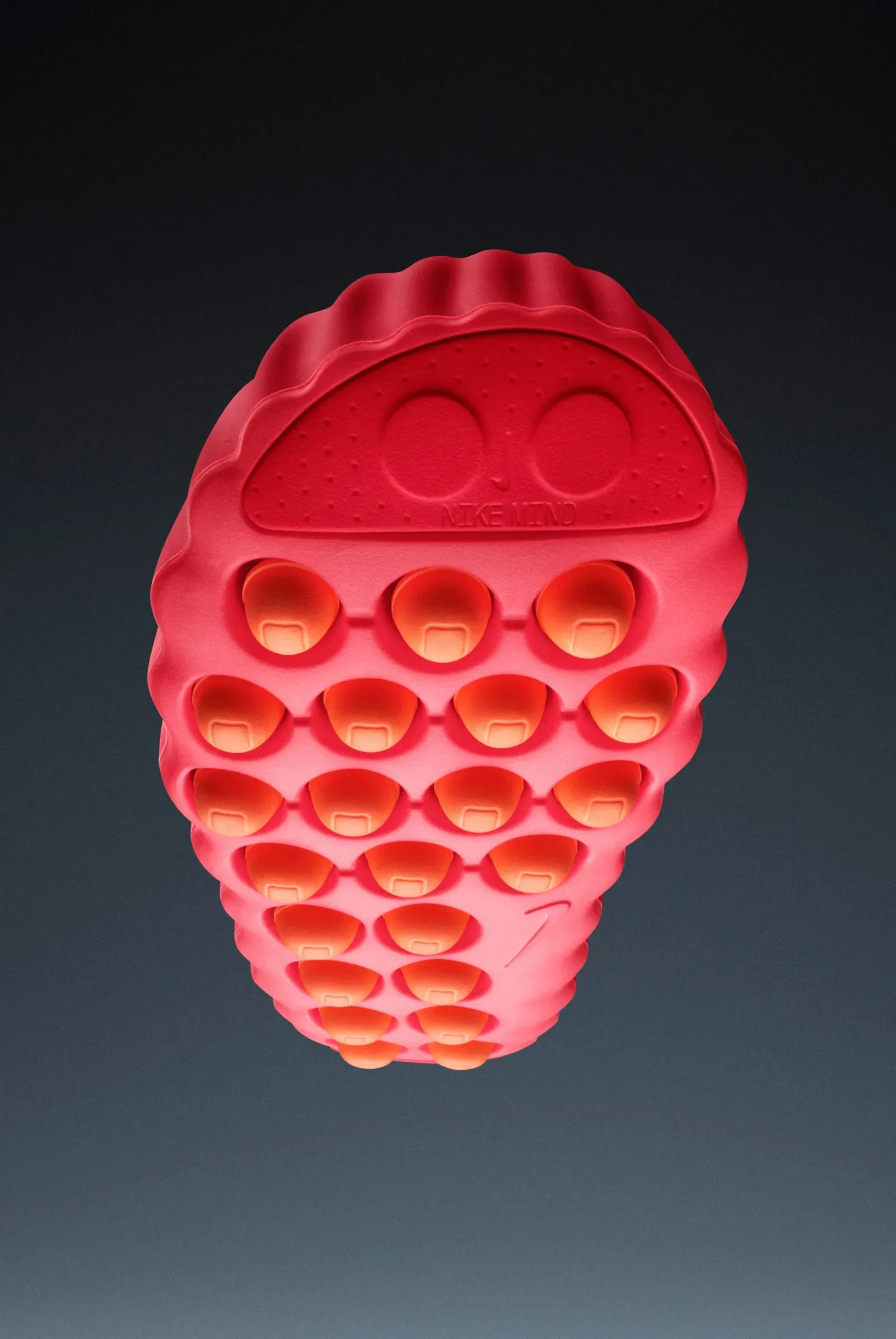 Underside of a red Nike Mind shoe, its 22 orange foam nodes set in rows and Nike Mind embossed at one end