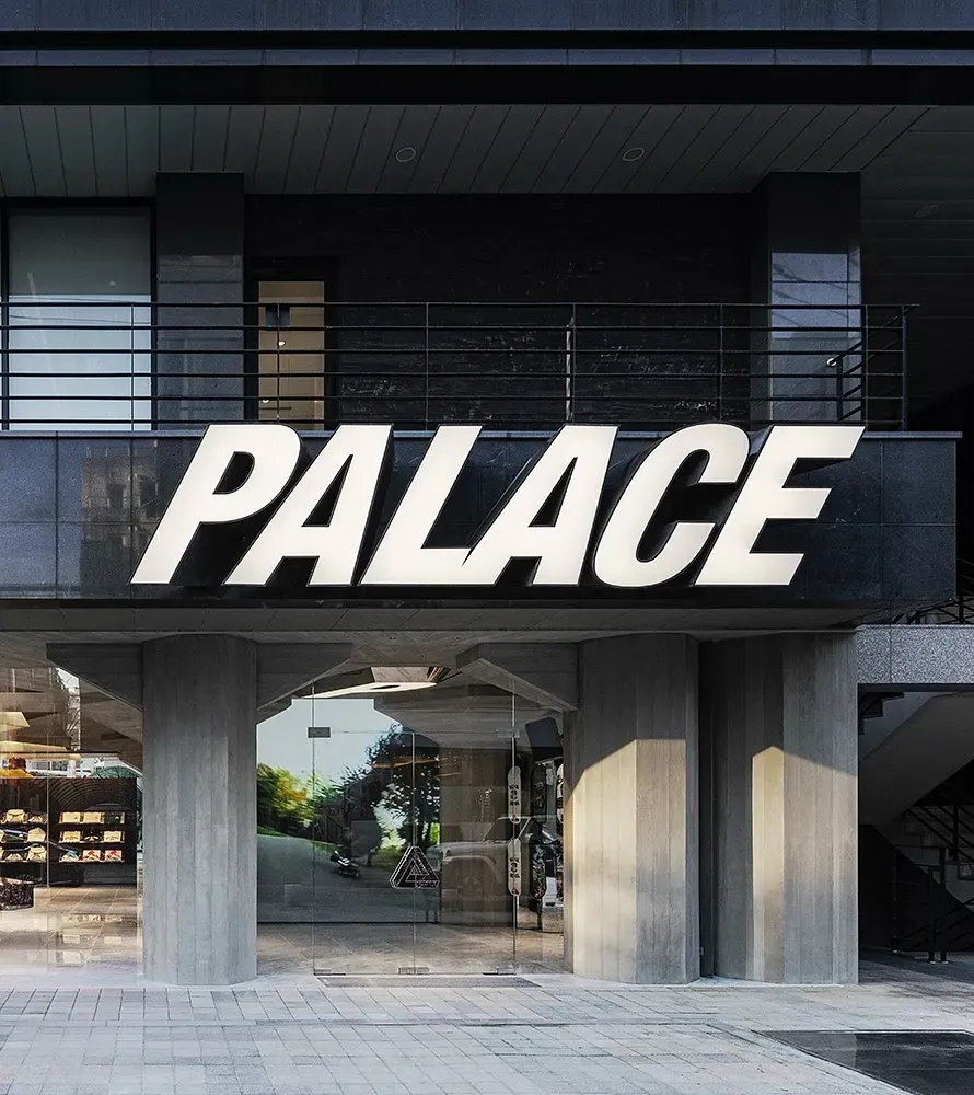 Big white PALACE letters above the glass entrance of the brand’s new Seoul store, set between concrete pillars