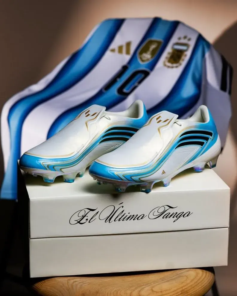 adidas F50 El Último Tango boots in white and sky blue on their box, an Argentina number 10 shirt draped behind