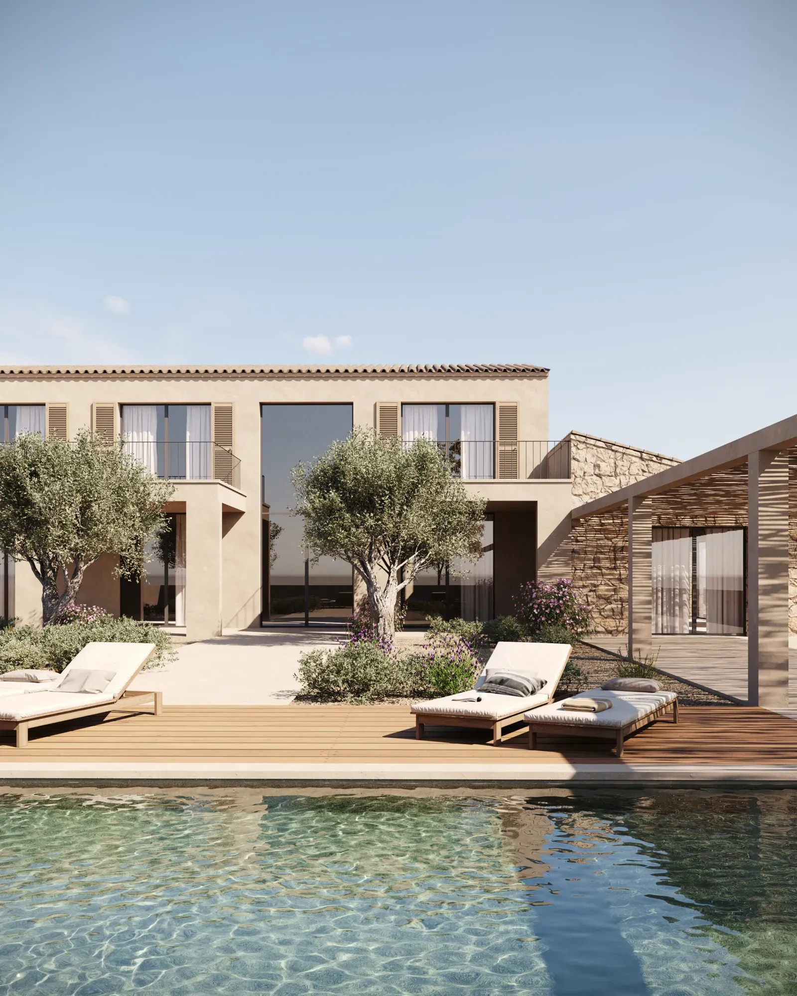Sand-coloured two-storey villa with olive trees, sun loungers on a wooden deck and a clear pool in front
