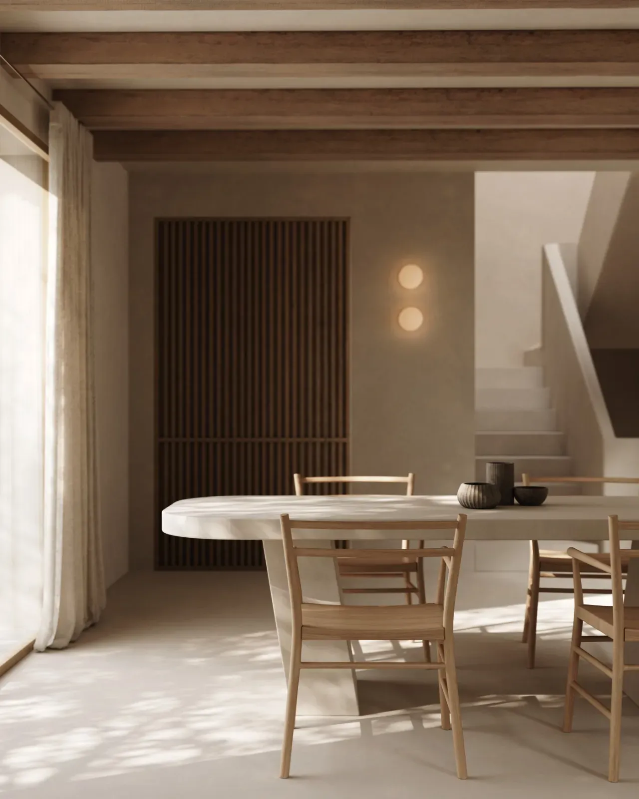Dining room with a pale oval table, light wooden chairs, timber ceiling beams, a slatted wood panel and a plaster staircase